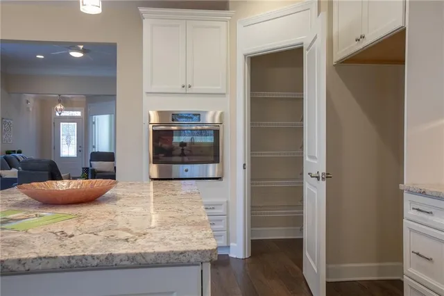a kitchen with granite countertop a refrigerator and cabinets