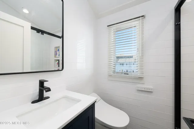 a bathroom with a sink toilet and mirror