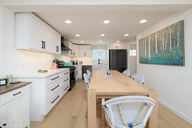 a kitchen with kitchen island white cabinets and black appliances