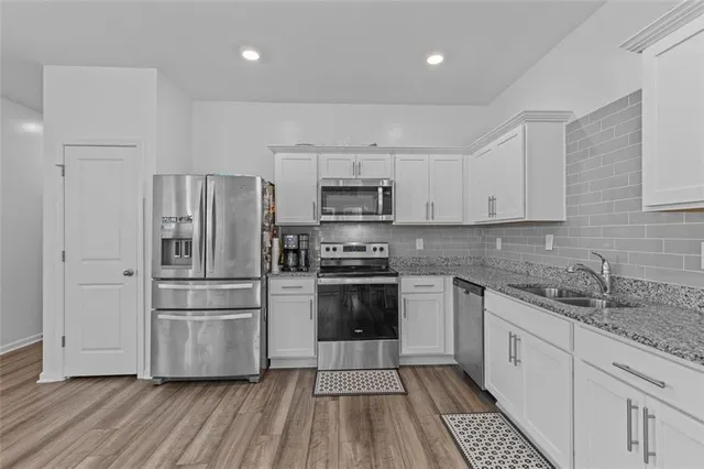 a kitchen with a refrigerator and a stove top oven