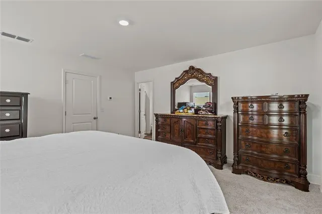 a bedroom with a bed and a mirror on dresser