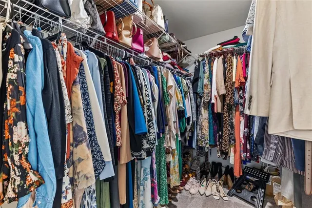 a view of walk in closet with clothes
