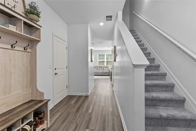 a view of a livingroom with wooden floor and stairs