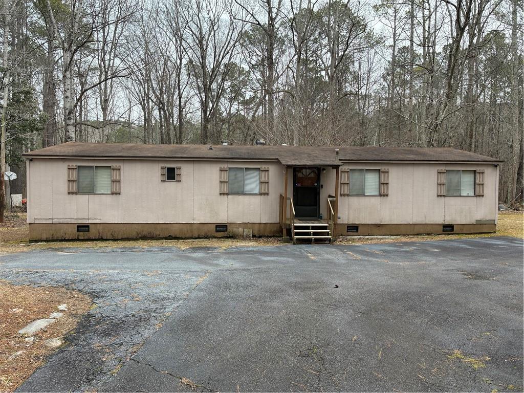 a view of a house with backyard and trees in the background