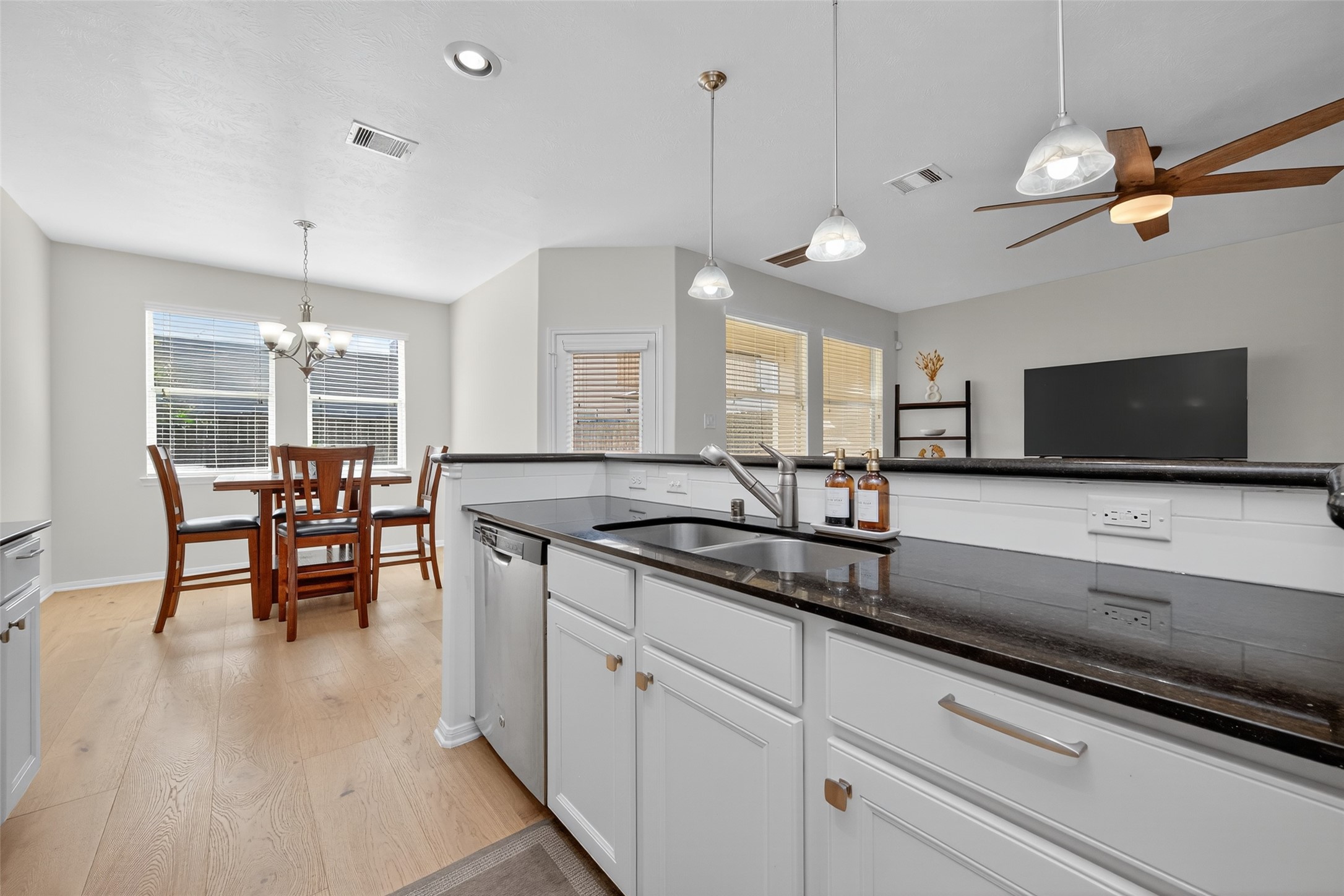 2806 Windy Thicket Lane Houston, TX 77082 - Photo 13 of 38 a kitchen with stainless steel appliances granite countertop a stove a sink a dining table and chairs with wooden floor