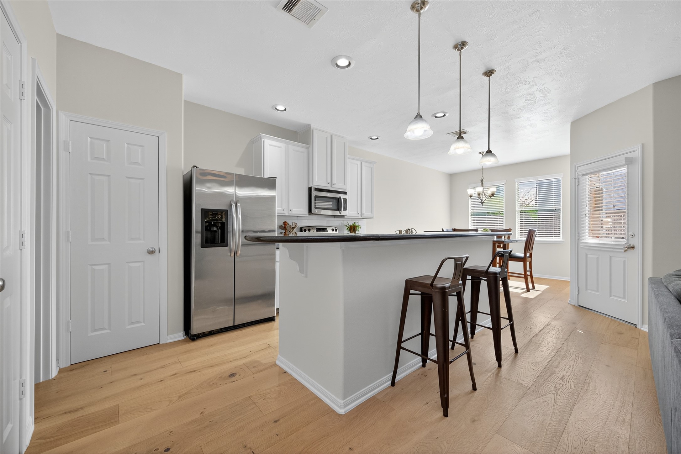 2806 Windy Thicket Lane Houston, TX 77082 - Photo 15 of 38 a kitchen with stainless steel appliances granite countertop a refrigerator a sink dishwasher a stove and white cabinets with wooden floor