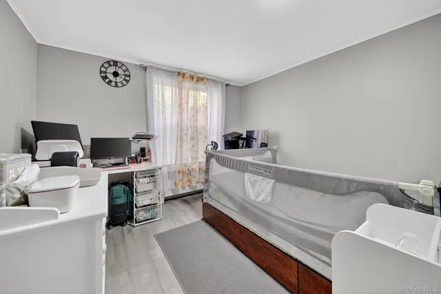 a bedroom with a bed and a computer on a desk