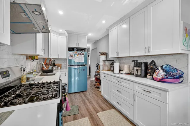 a kitchen with white cabinets and appliances