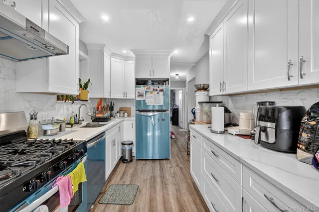 a kitchen with stainless steel appliances granite countertop a stove refrigerator sink and cabinets