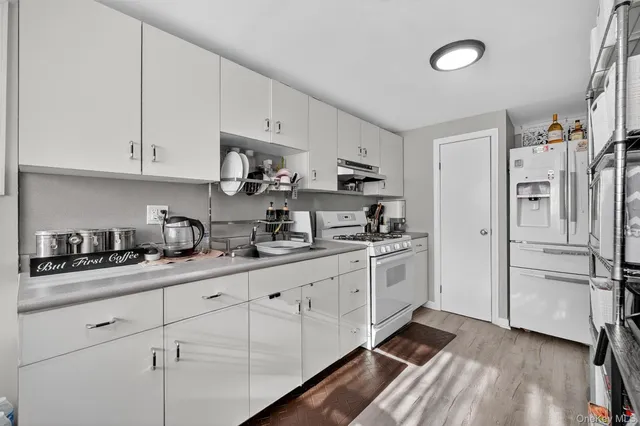 a kitchen with granite countertop white cabinets and white appliances