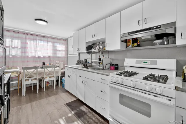 a kitchen with stainless steel appliances a stove a sink and cabinets