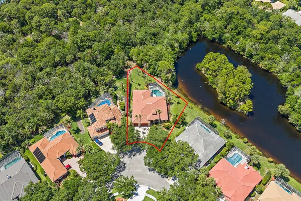 an aerial view of a house with a yard and lake view