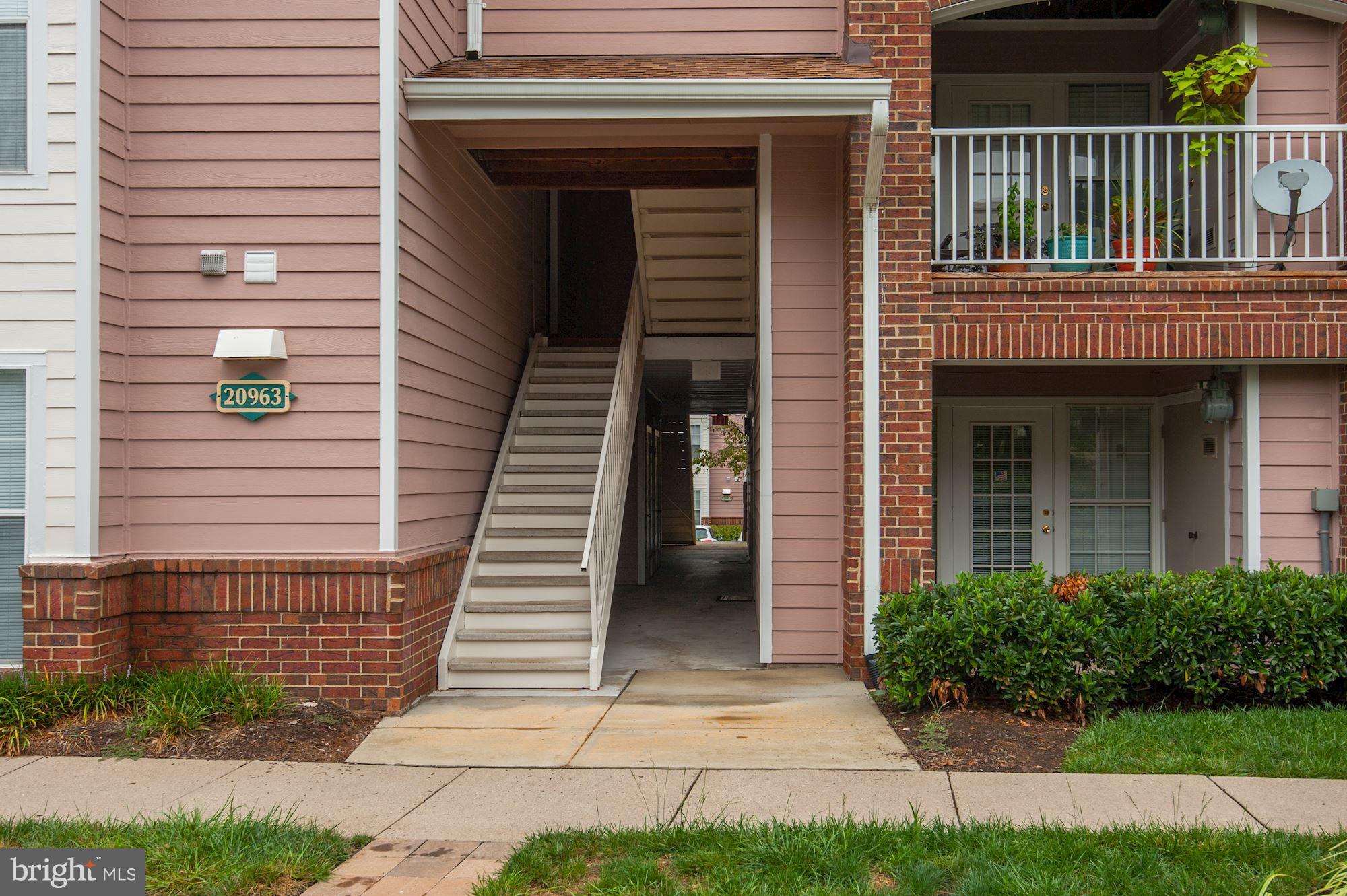 20963 Timber Ridge Terrace, Unit 202 Ashburn, VA 20147 - Photo 2 of 22 a view of a house with a small yard and wooden floor and fence