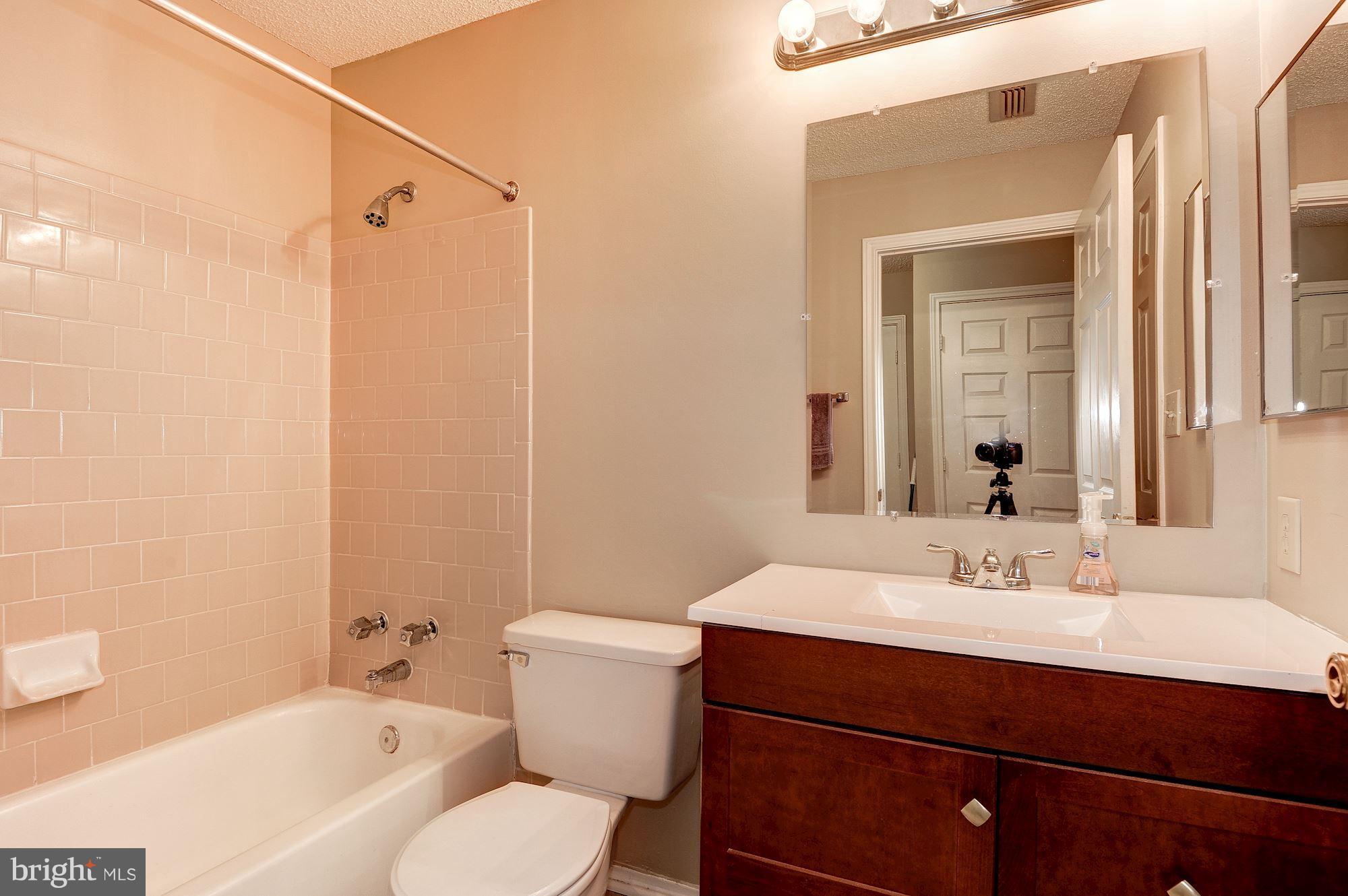 20963 Timber Ridge Terrace, Unit 202 Ashburn, VA 20147 - Photo 14 of 22 a bathroom with a sink a toilet and shower