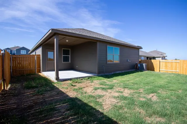 a backyard of a house with dishwasher and wooden fence
