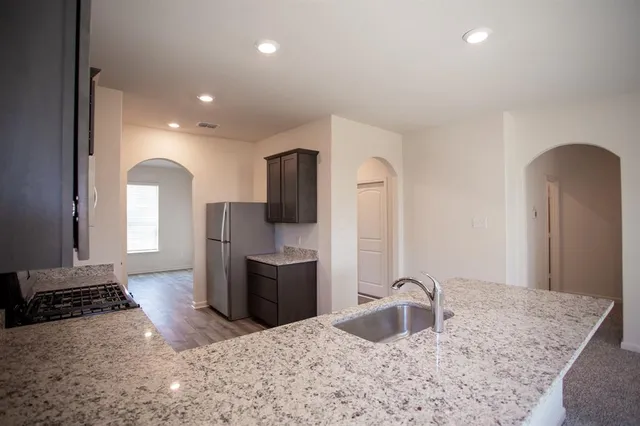 a kitchen with sink refrigerator and stove