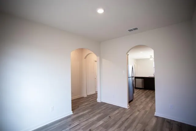 an empty room with windows and fan