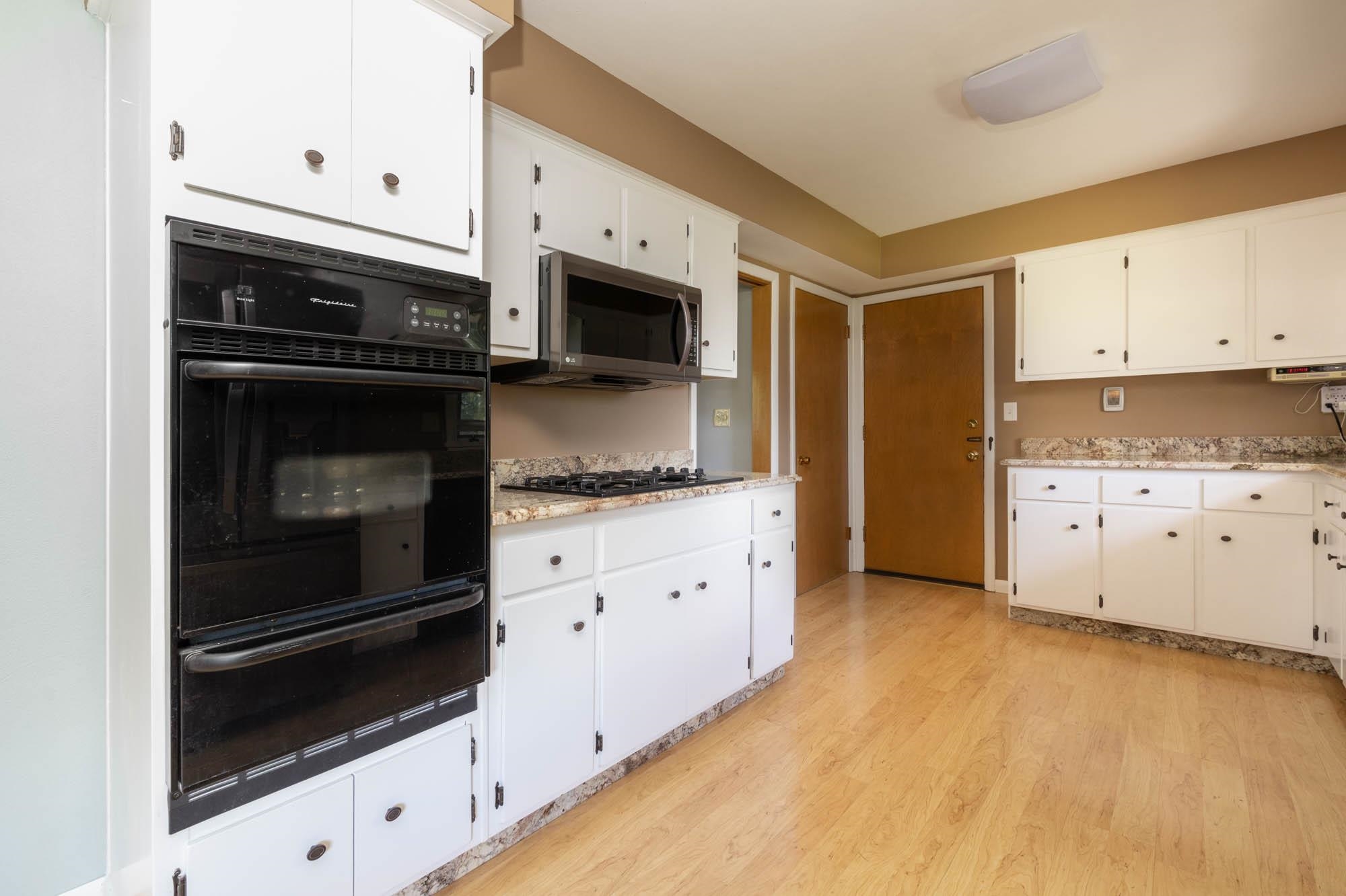 203 Wood Road Rockford, IL 61107 - Photo 9 of 32 a kitchen with granite countertop white cabinets and appliances