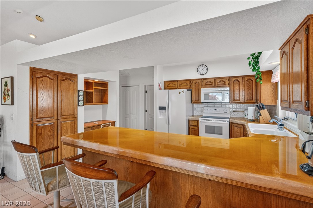 2055 Cholla Way Laughlin, NV 89029 - Photo 20 of 87 A well-equipped kitchen boasts practical wood cabinetry and a functional breakfast bar for casual dining.