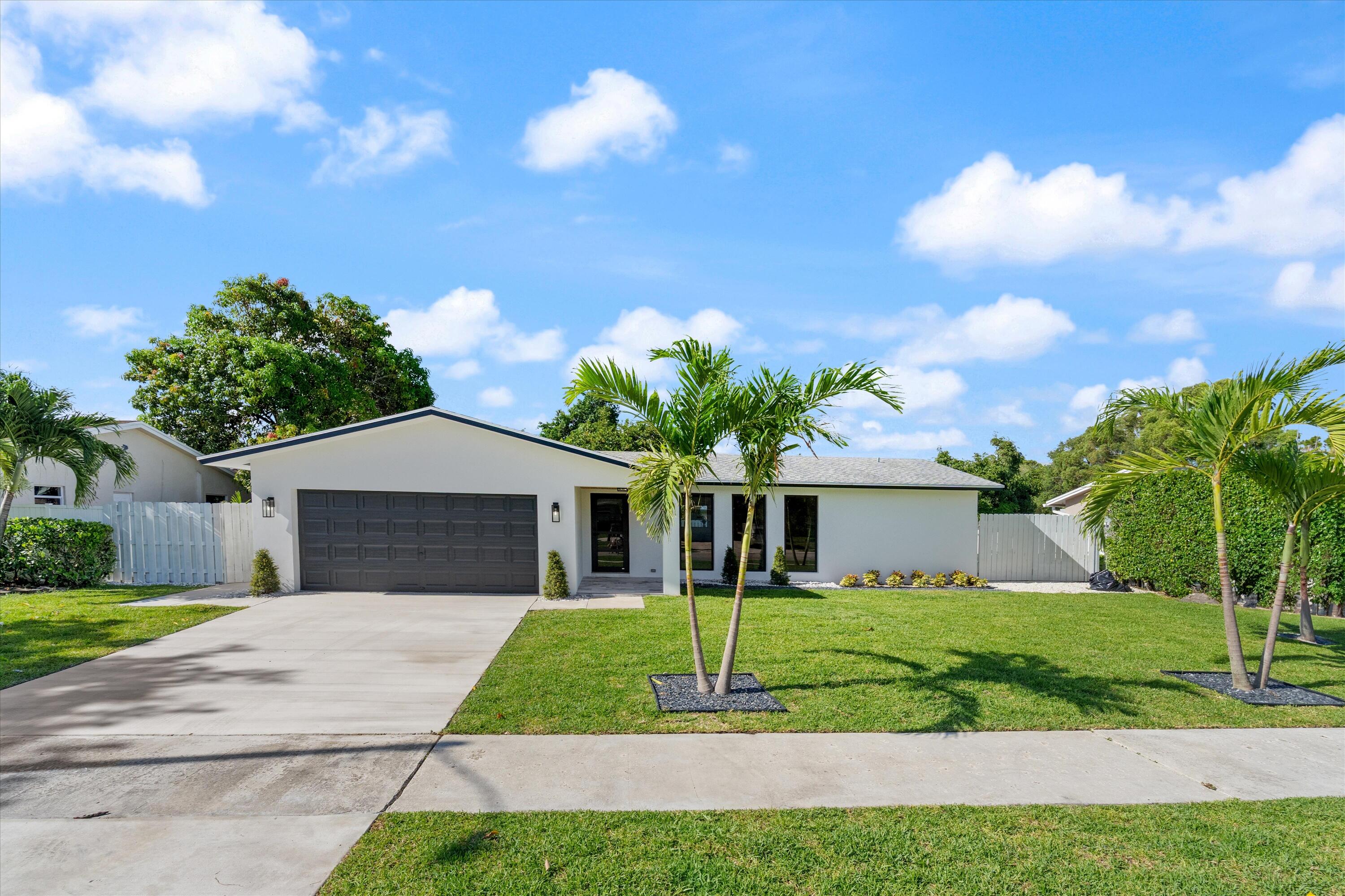 1780 Southwest 9th Street Boca Raton, FL 33486 - Photo 1 of 67 a front view of a house with a yard and garage