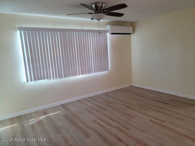 1700 Chaucer Road Titusville, FL 32780 - Photo 8 of 15 a view of an empty room with wooden floor and a window