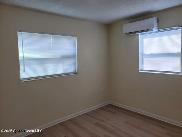 a view of a small space with wooden floor and a window