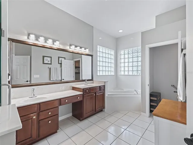 a spacious bathroom with a granite countertop sink mirror and cabinets
