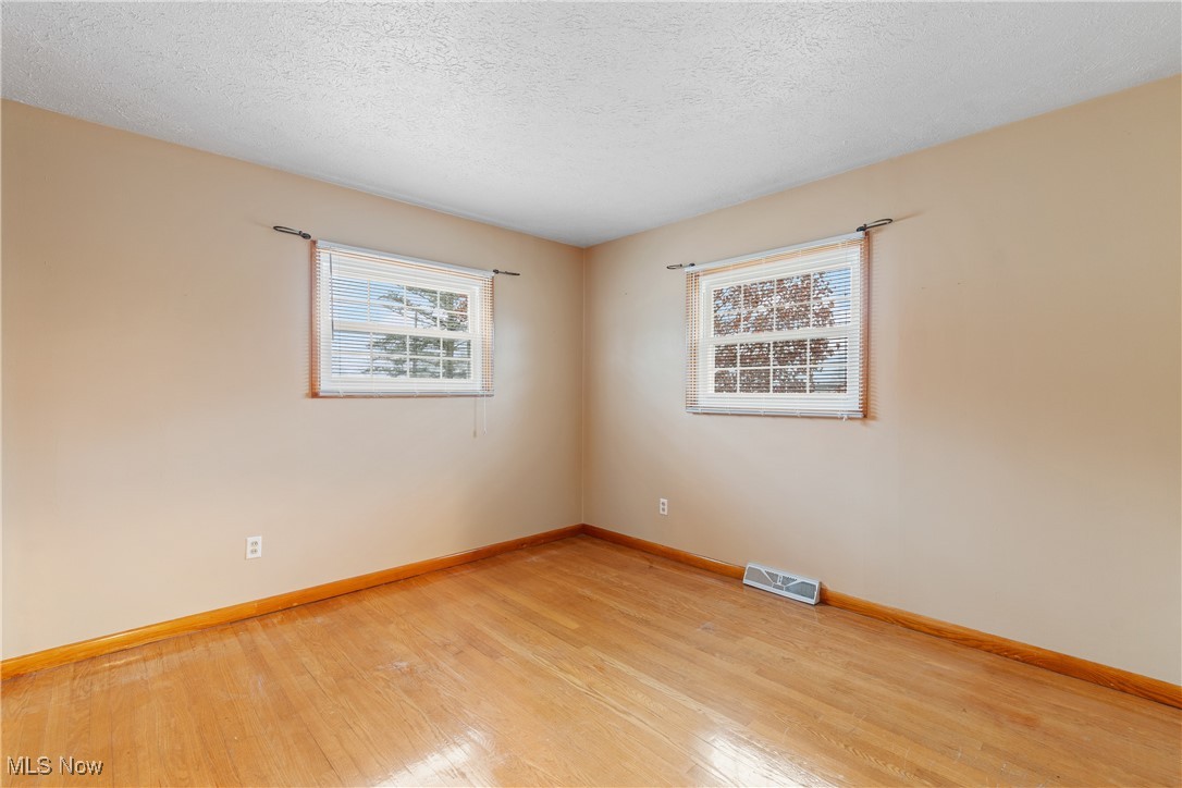 241 Baker Street Rittman, OH 44270 - Photo 14 of 25 Spare room featuring light hardwood / wood-style floors and a textured ceiling