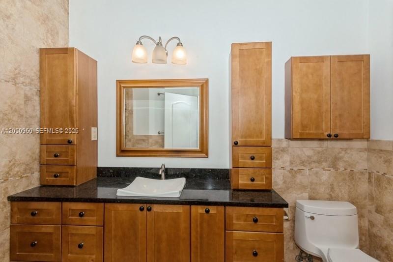 10884 Southwest 89th Street Miami, FL 33176 - Photo 5 of 10 a bathroom with a granite countertop sink toilet and mirror