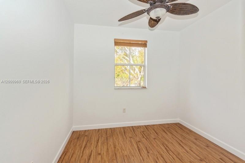 10884 Southwest 89th Street Miami, FL 33176 - Photo 7 of 10 a view of an empty room with wooden floor and a window