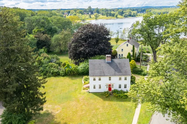 an aerial view of a house with a garden and lake view