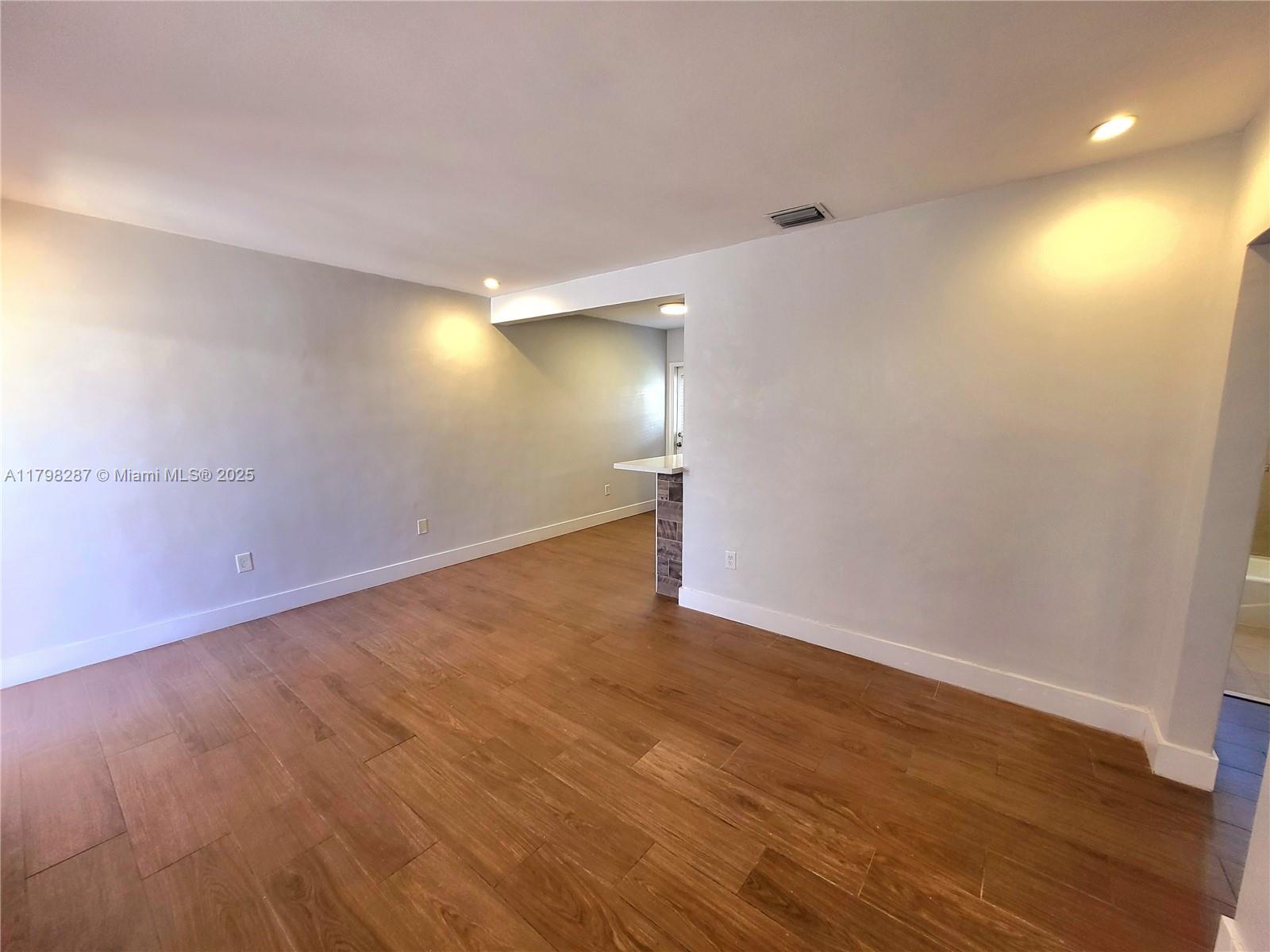 2355 Southwest 27th Street, Unit 4 Miami, FL 33133 - Photo 13 of 25 a view of an empty room with wooden floor