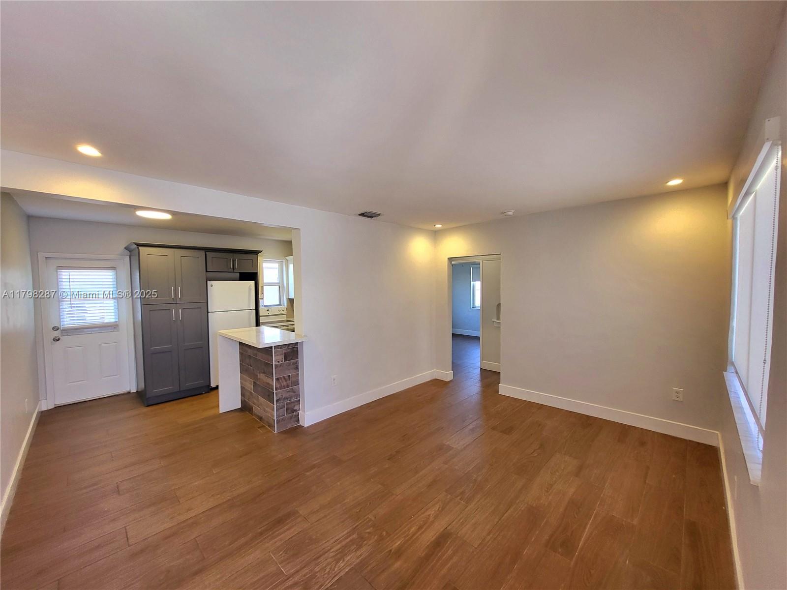 2355 Southwest 27th Street, Unit 4 Miami, FL 33133 - Photo 20 of 25 a view of an empty room with window and wooden floor