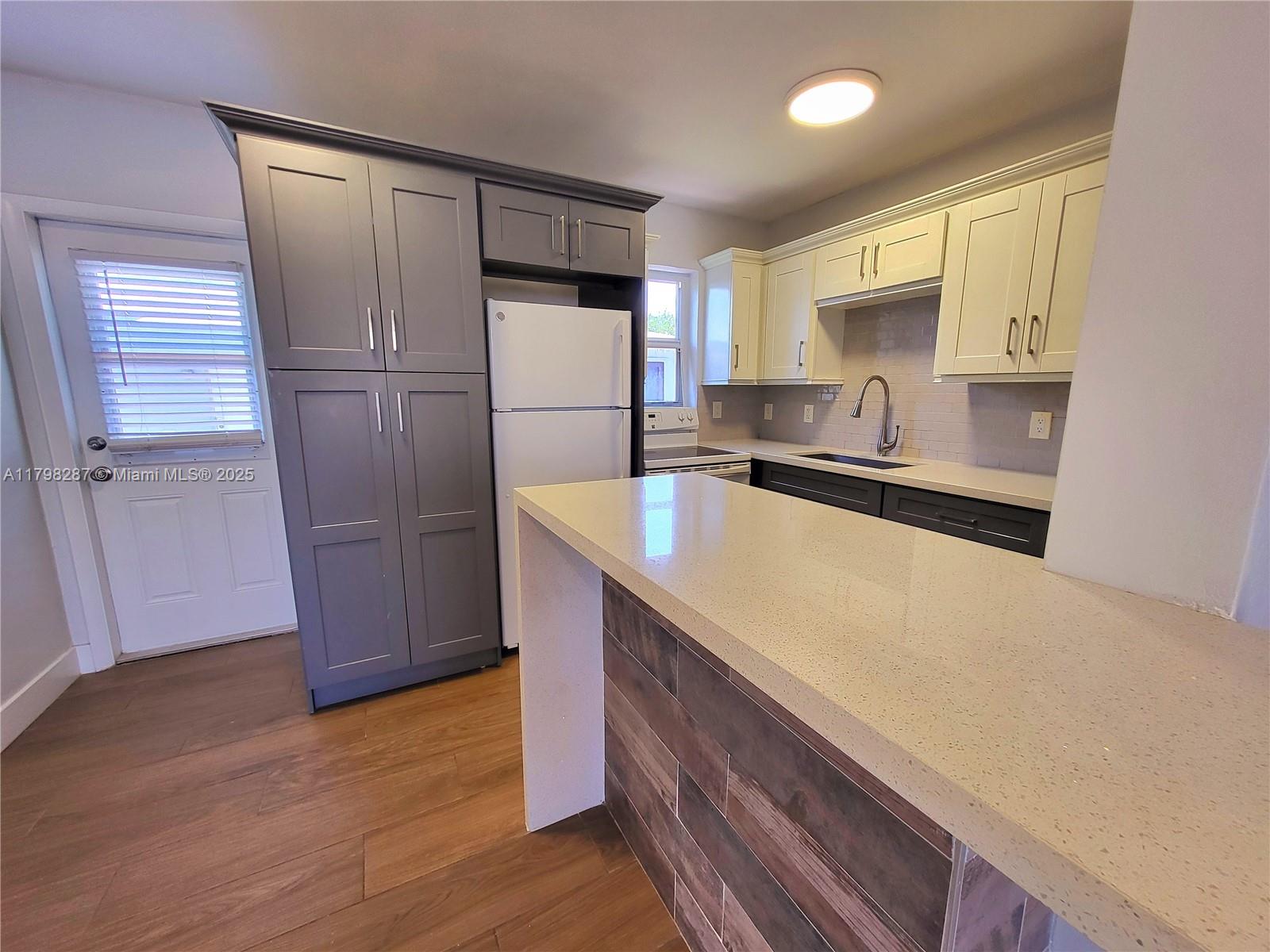 2355 Southwest 27th Street, Unit 4 Miami, FL 33133 - Photo 2 of 25 a kitchen with stainless steel appliances a refrigerator and a sink