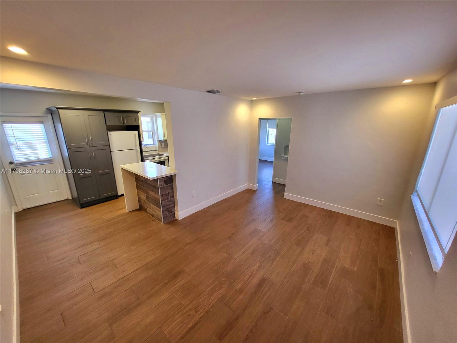 2355 Southwest 27th Street, Unit 4 Miami, FL 33133 - Photo 3 of 25 a view of empty room with wooden floor and fan