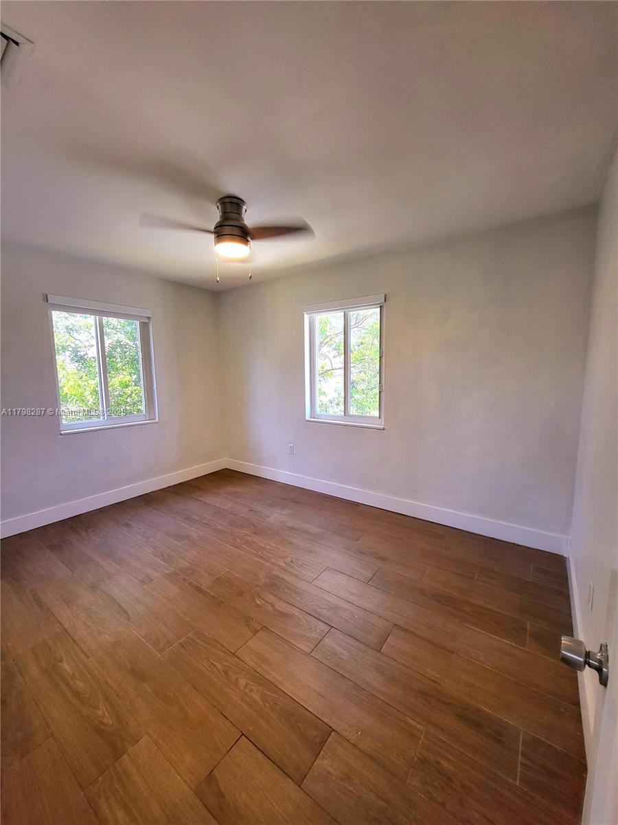 2355 Southwest 27th Street, Unit 4 Miami, FL 33133 - Photo 7 of 25 an empty room with windows and ceiling fan
