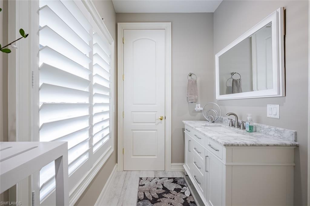 1942 Kingfish Road Naples, FL 34102 - Photo 30 of 43 a bathroom with a sink a vanity and a mirror