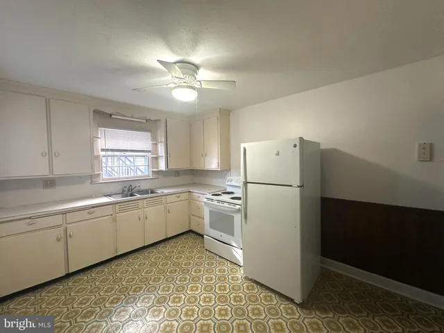 a kitchen with a white refrigerator freezer a sink and dishwasher