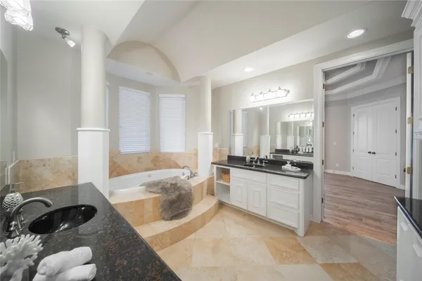 a large bathroom with a tub a sink and a mirror