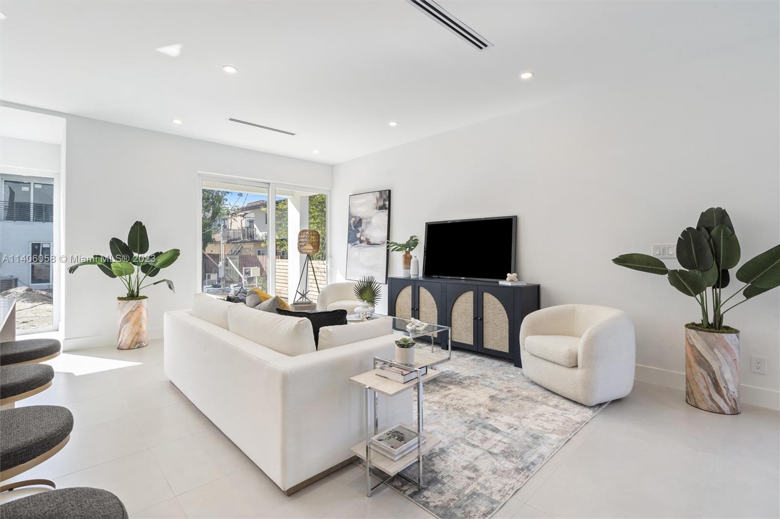 2290 Southeast 6th Street Pompano Beach, FL 33062 - Photo 12 of 22 a living room with furniture a flat screen tv and a potted plant