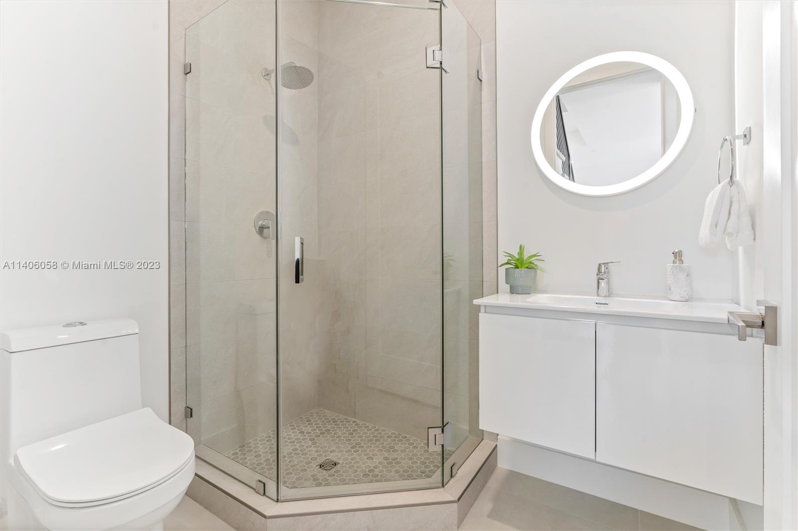 2290 Southeast 6th Street Pompano Beach, FL 33062 - Photo 13 of 22 a bathroom with a toilet a sink a vanity and mirror