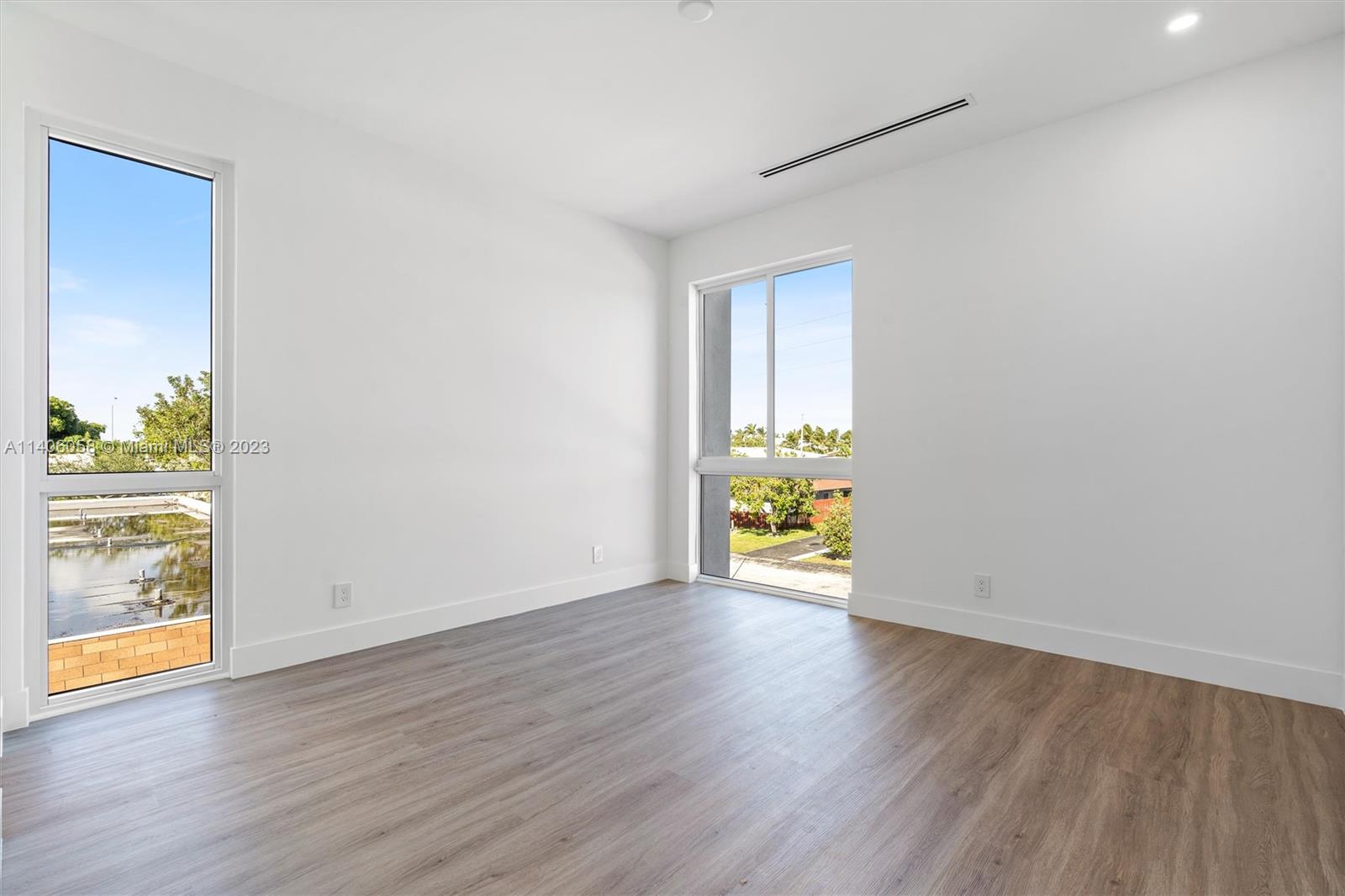 2290 Southeast 6th Street Pompano Beach, FL 33062 - Photo 18 of 22 a view of an empty room with wooden floor and a window