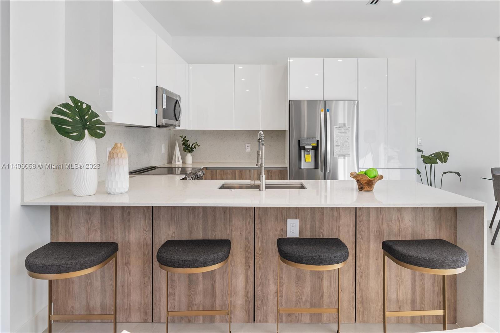 2290 Southeast 6th Street Pompano Beach, FL 33062 - Photo 4 of 22 a kitchen with a kitchen island and chairs in it