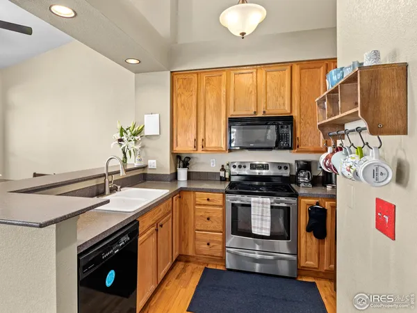 a kitchen with a refrigerator a stove a sink a counter space and a window