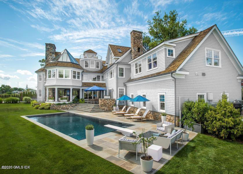 a front view of a house with garden and sitting area