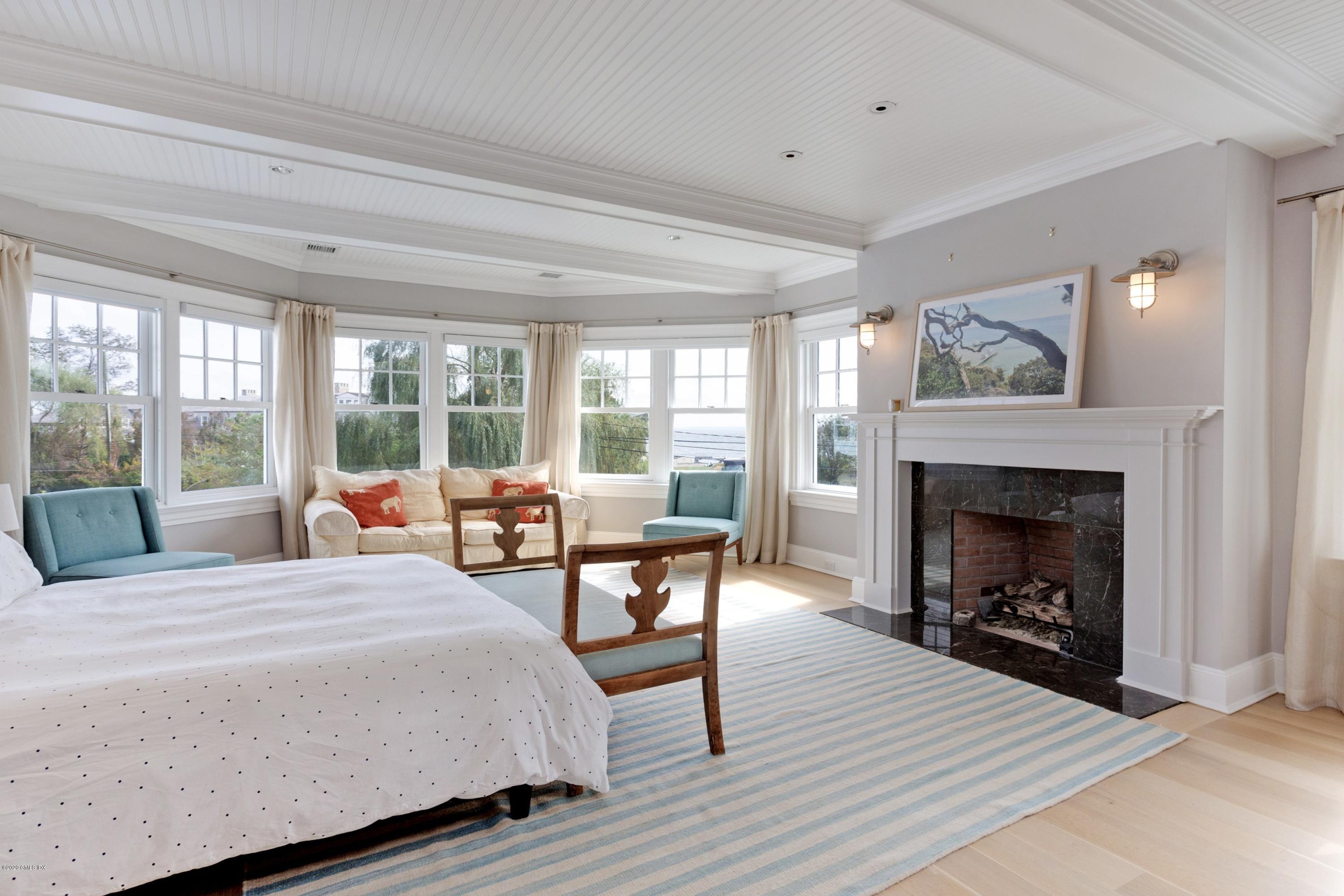 186 Shore Road Old Greenwich, CT 06870 - Photo 18 of 37 a bedroom with a large bed and a fireplace