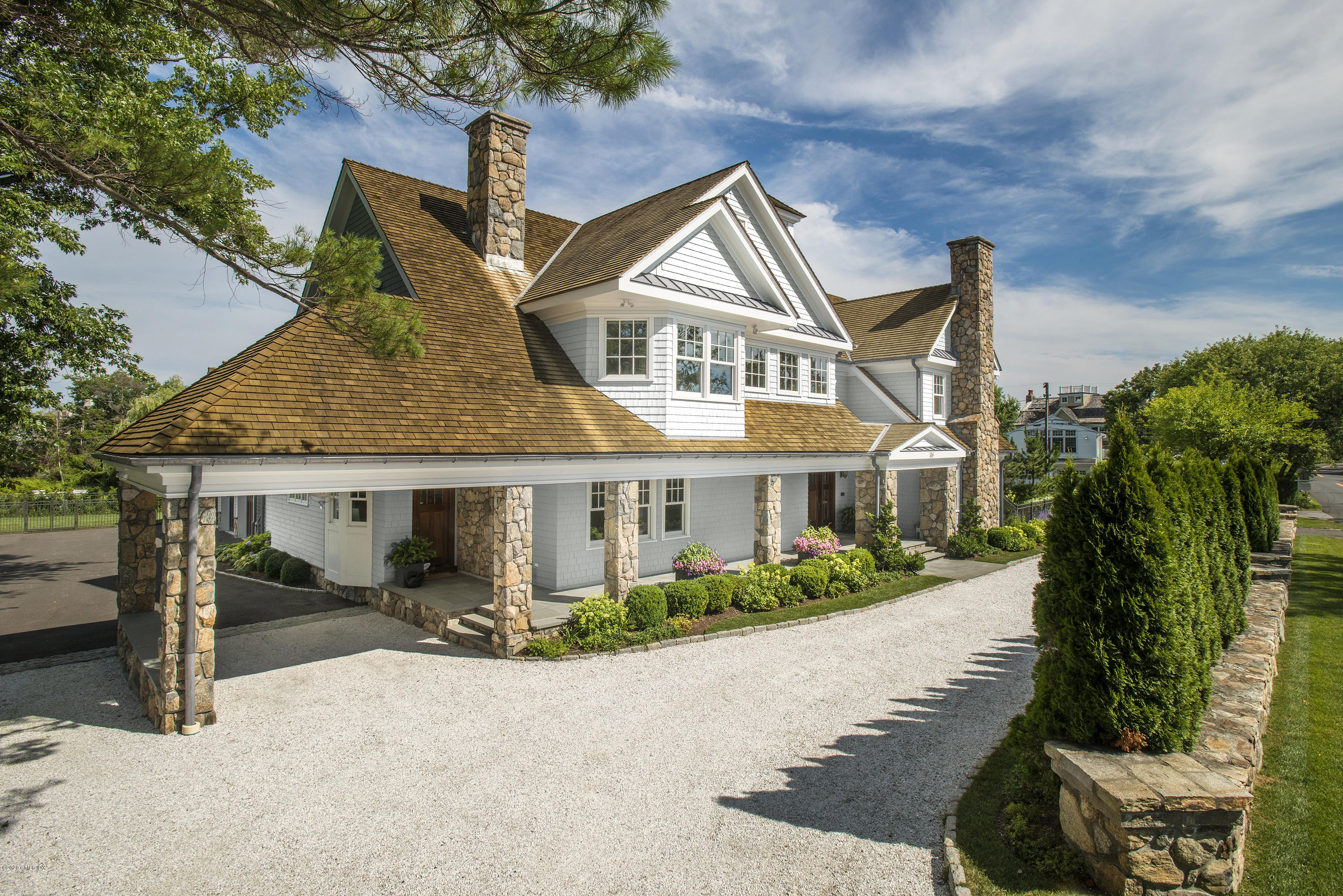 186 Shore Road Old Greenwich, CT 06870 - Photo 2 of 37 a front view of a house with a yard and potted plants