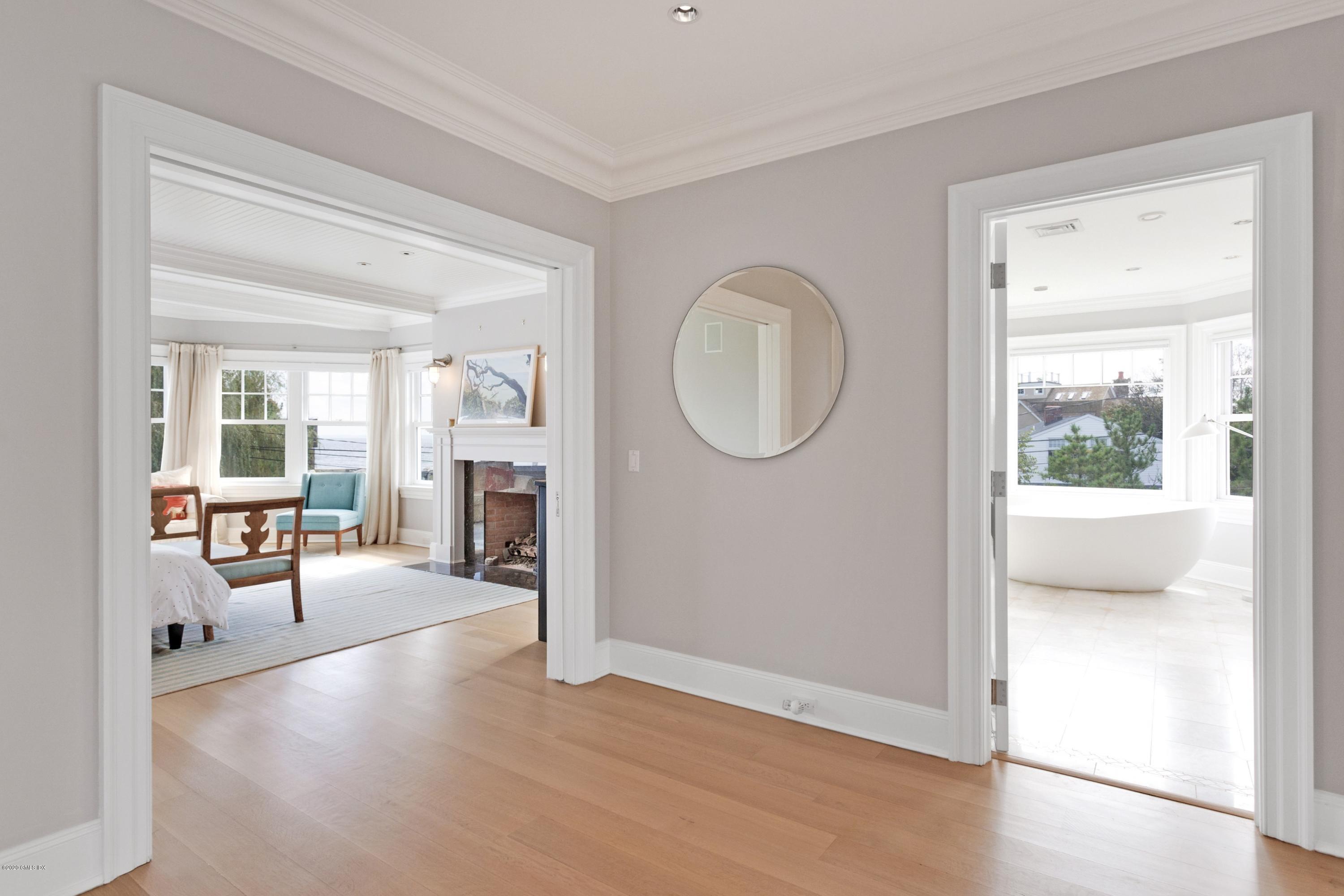 186 Shore Road Old Greenwich, CT 06870 - Photo 22 of 37 a view of a livingroom with furniture a fireplace wooden floor and windows
