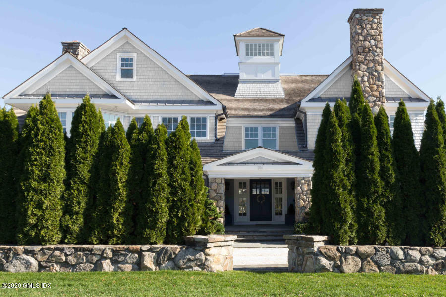186 Shore Road Old Greenwich, CT 06870 - Photo 3 of 37 a front view of a house with a yard table and chairs