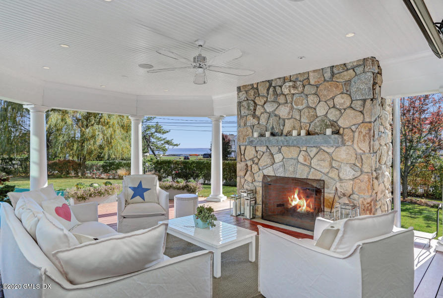 186 Shore Road Old Greenwich, CT 06870 - Photo 34 of 37 a living room with furniture a fireplace and a floor to ceiling window